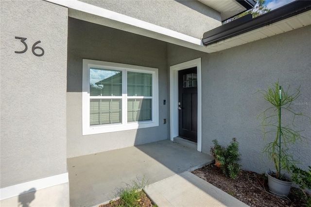 view of exterior entry with stucco siding