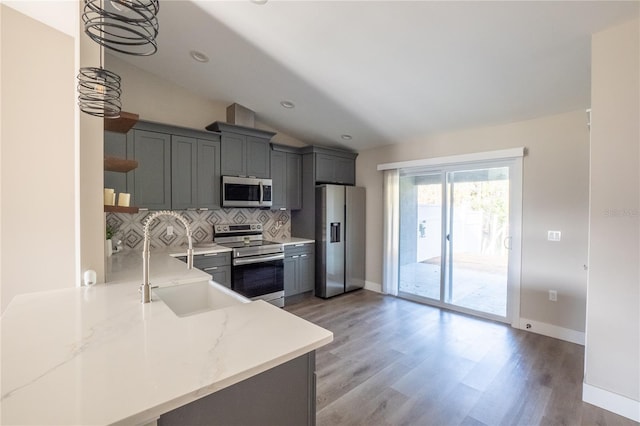 kitchen with decorative backsplash, appliances with stainless steel finishes, vaulted ceiling, open shelves, and a sink