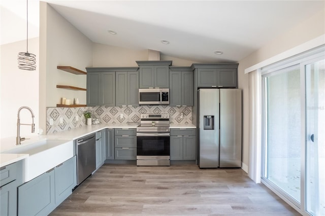 kitchen with open shelves, stainless steel appliances, lofted ceiling, light wood-style flooring, and gray cabinetry