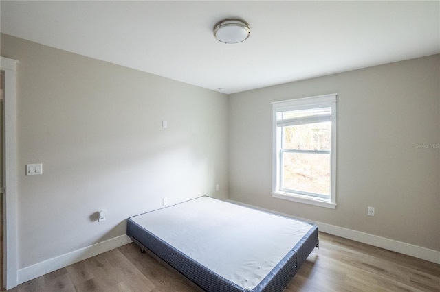 bedroom featuring baseboards and wood finished floors