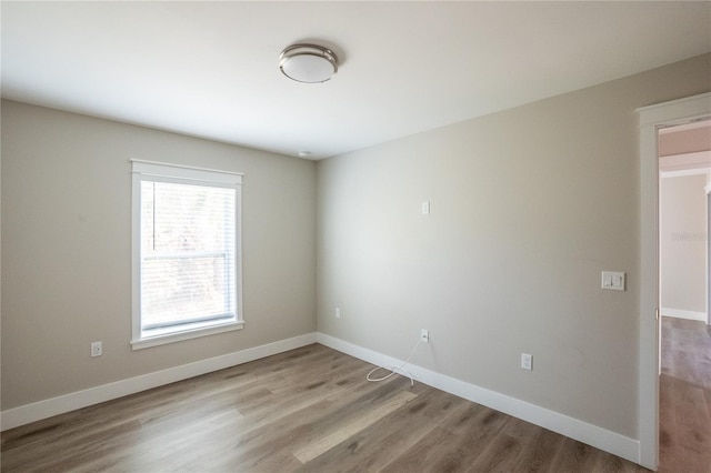 spare room featuring wood finished floors and baseboards