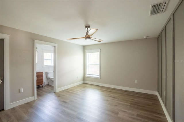 unfurnished bedroom with light wood finished floors, baseboards, multiple windows, and visible vents