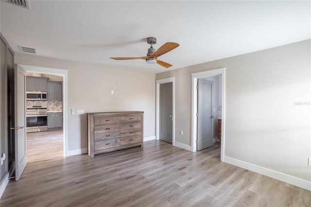 unfurnished bedroom featuring a ceiling fan, light wood-style flooring, visible vents, and baseboards