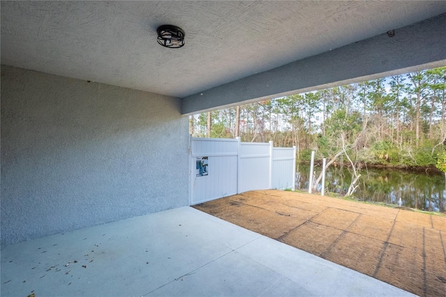 view of patio / terrace with a water view and fence