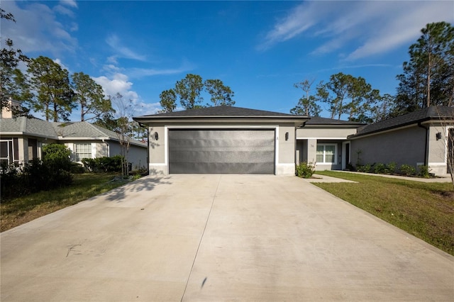 view of front of house featuring a garage, a front yard, concrete driveway, and stucco siding