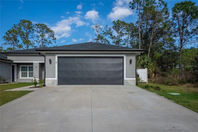 view of front facade with concrete driveway, an attached garage, and stucco siding