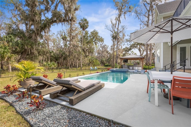 outdoor pool featuring a patio, a lawn, a gazebo, fence, and an in ground hot tub