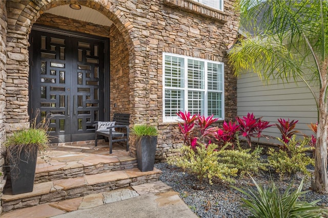 property entrance with covered porch and stone siding