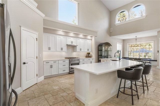 kitchen with stone tile floors, stainless steel appliances, a sink, and light countertops