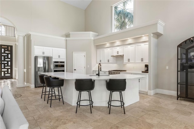 kitchen featuring a healthy amount of sunlight, decorative columns, appliances with stainless steel finishes, and a sink