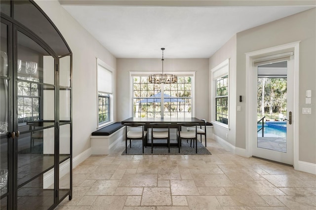 dining room featuring plenty of natural light, baseboards, and stone tile flooring