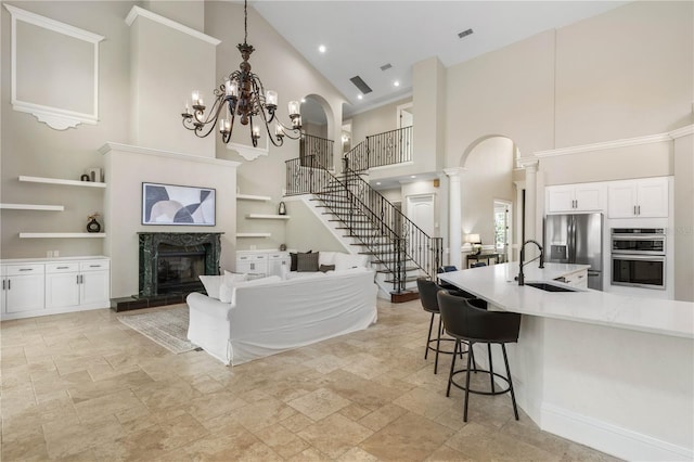 interior space with arched walkways, a breakfast bar area, stainless steel appliances, a fireplace, and a sink