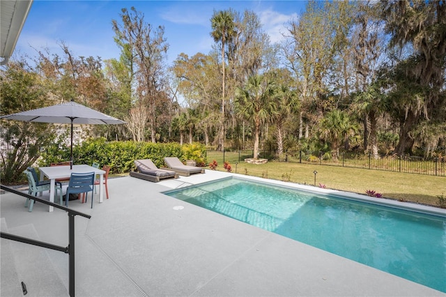 view of pool with a patio area, fence, a lawn, and outdoor dining space