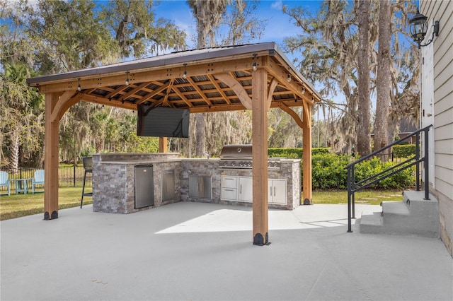 view of patio / terrace with area for grilling, fence, exterior kitchen, a gazebo, and a detached carport