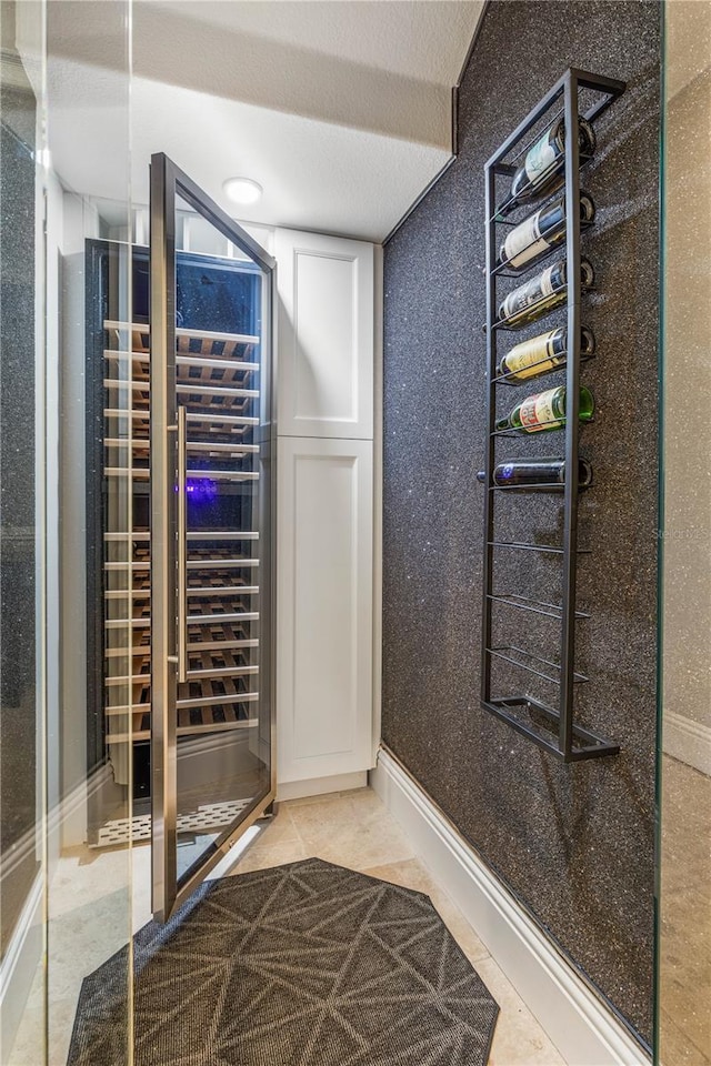 wine area with beverage cooler, baseboards, and tile patterned floors