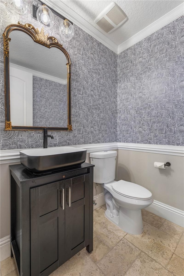 half bathroom with visible vents, baseboards, toilet, a textured ceiling, and vanity