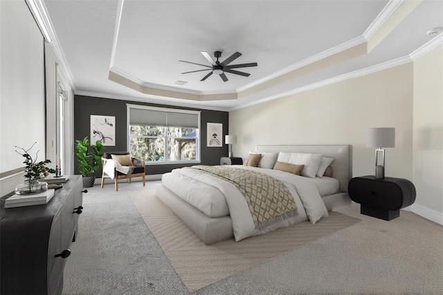 carpeted bedroom featuring visible vents, baseboards, a ceiling fan, ornamental molding, and a tray ceiling