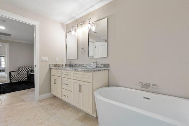 ensuite bathroom with double vanity, baseboards, visible vents, a soaking tub, and ensuite bath