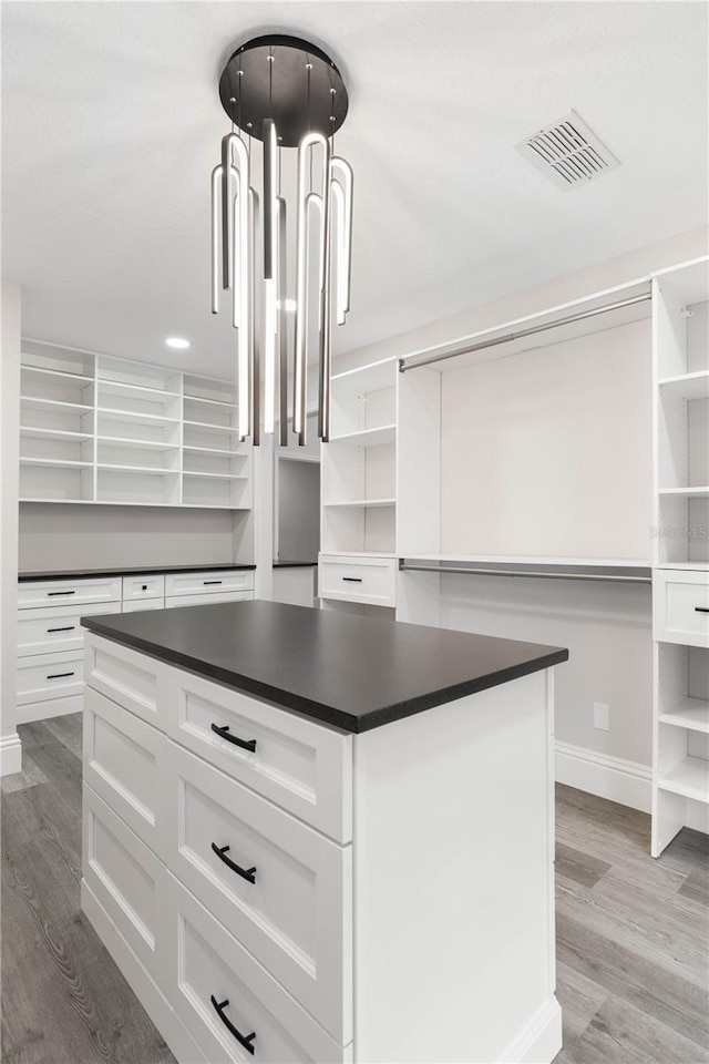 spacious closet featuring light wood-type flooring and visible vents