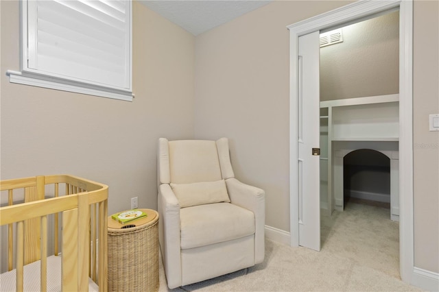 carpeted bedroom with a nursery area, a textured ceiling, visible vents, and baseboards