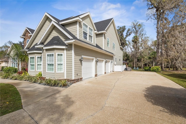 view of side of property featuring a garage and concrete driveway