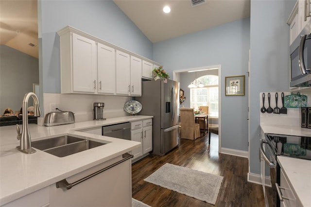 kitchen with stainless steel appliances, lofted ceiling, decorative backsplash, dark wood-type flooring, and a sink