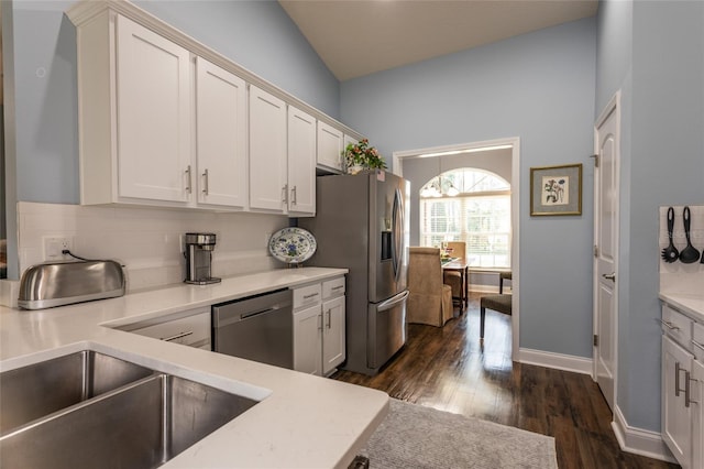 kitchen featuring white cabinets, baseboards, appliances with stainless steel finishes, backsplash, and dark wood-style floors