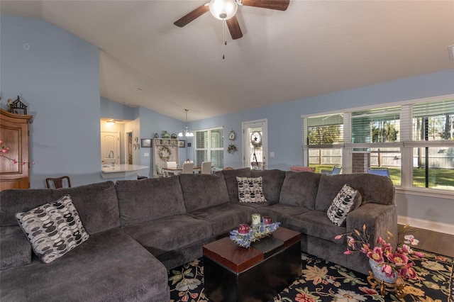 living room featuring ceiling fan, vaulted ceiling, baseboards, and wood finished floors