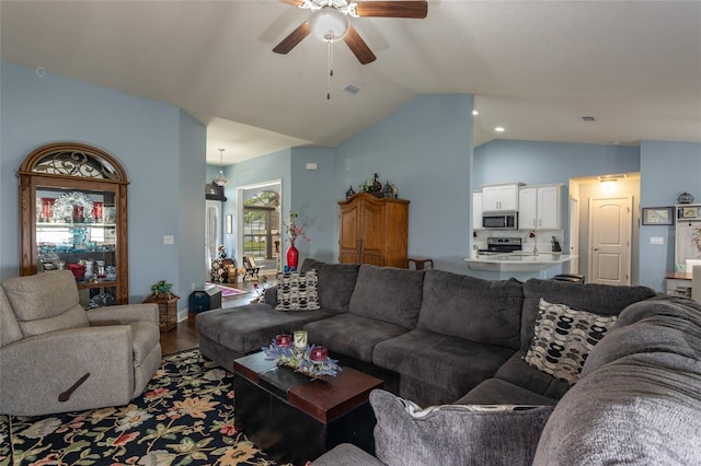 living room featuring a ceiling fan, visible vents, vaulted ceiling, and wood finished floors