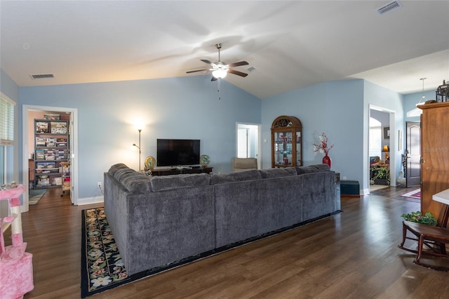 living room featuring dark wood-style floors, lofted ceiling, and visible vents