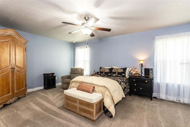 carpeted bedroom featuring a ceiling fan, a textured ceiling, and baseboards