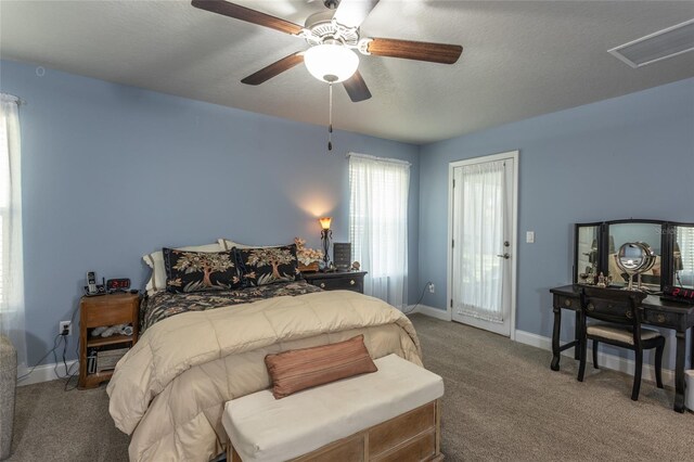 carpeted bedroom with visible vents, ceiling fan, a textured ceiling, and baseboards