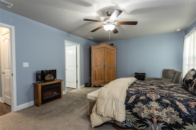 carpeted bedroom featuring a textured ceiling, ceiling fan, visible vents, and baseboards