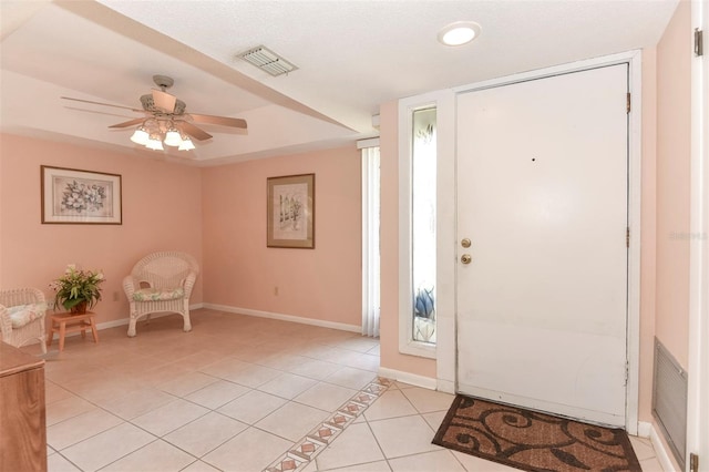 entryway with light tile patterned flooring, ceiling fan, visible vents, and baseboards