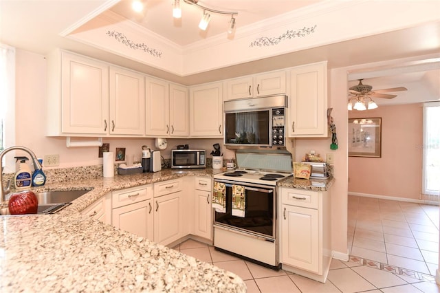 kitchen featuring range with electric cooktop, a raised ceiling, stainless steel microwave, and a sink