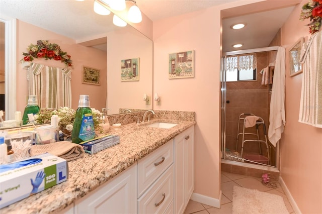 full bathroom featuring tile patterned flooring, a shower stall, vanity, and baseboards