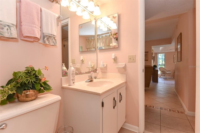 bathroom featuring vanity, tile patterned flooring, toilet, and baseboards