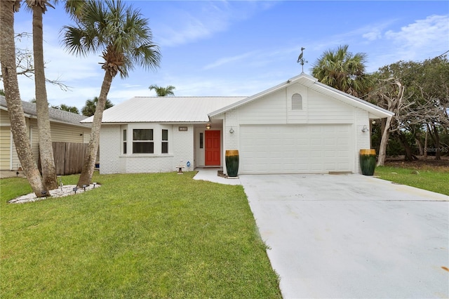 single story home with concrete driveway, metal roof, an attached garage, a front lawn, and brick siding