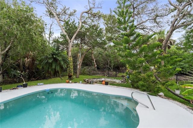 pool with fence and a lawn