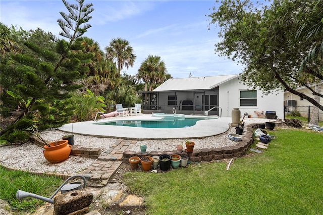 outdoor pool featuring a sunroom, a patio area, a lawn, and fence