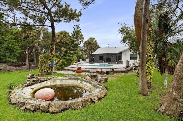 view of yard featuring a sunroom, fence, and an outdoor pool