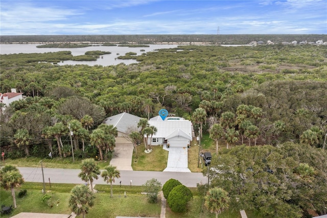 birds eye view of property featuring a water view and a wooded view