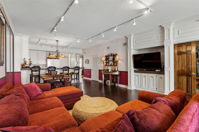 living room with dark wood-type flooring, visible vents, a textured ceiling, and an inviting chandelier