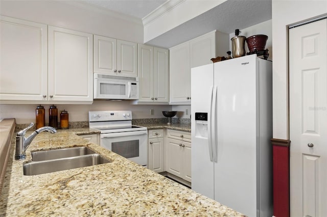 kitchen with light stone counters, white appliances, a sink, white cabinets, and ornamental molding