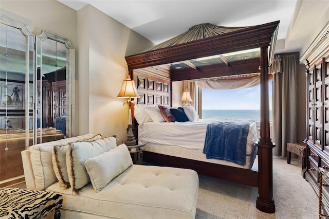 carpeted bedroom with a water view