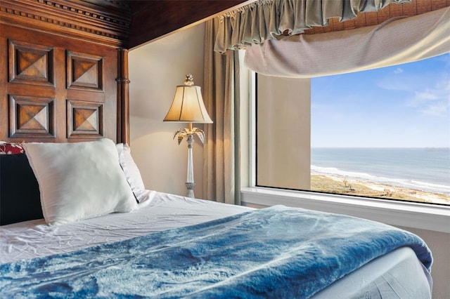 bedroom with a water view and a view of the beach