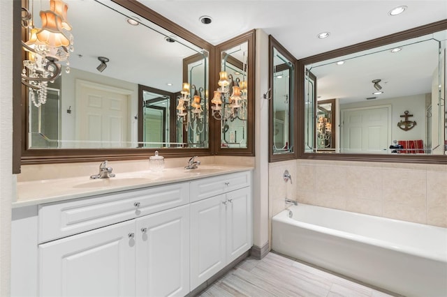 bathroom with recessed lighting, a sink, a bath, and double vanity