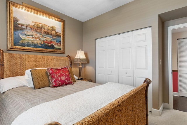 carpeted bedroom with a closet and baseboards