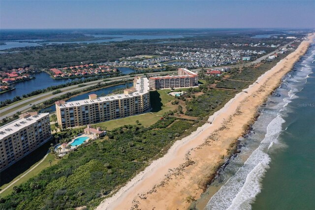 aerial view with a city view, a water view, and a beach view