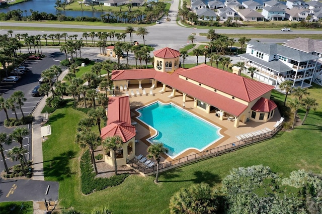 pool with a water view, a patio area, a residential view, and fence